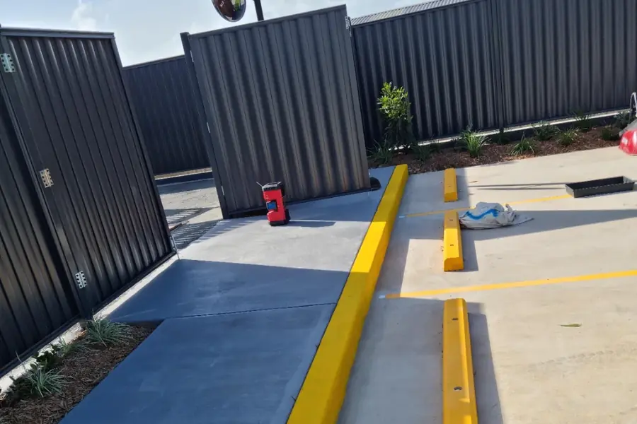 A dark colorbond clad commercial building exterior with yellow line markings