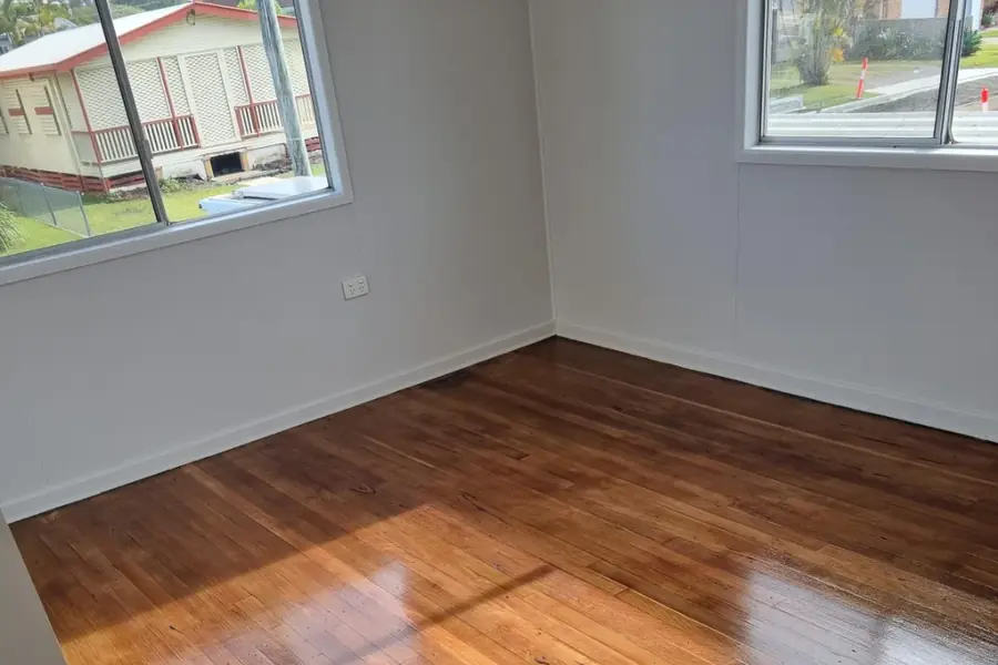 A sunlit room with richly polished warm timber floors